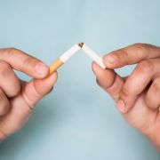 Mains qui brisent une cigarette en deux